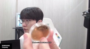 Faker给大家看纪念币实物：这是前面，是坐在王座上的样子，后面有星星